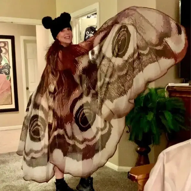 Moth wing cape draped over the shoulders